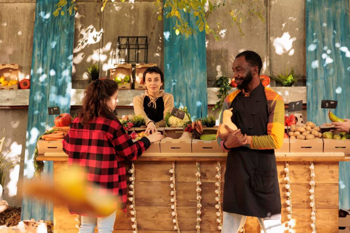 A vibrant market scene with fresh produce displayed, featuring a wooden stall, colorful vegetables, and engaged customers.